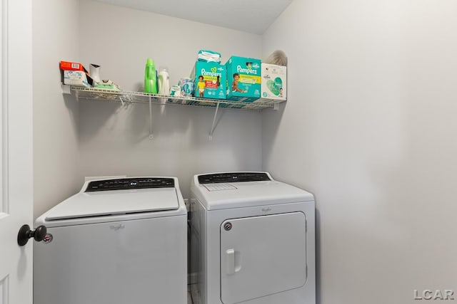 clothes washing area with separate washer and dryer and laundry area