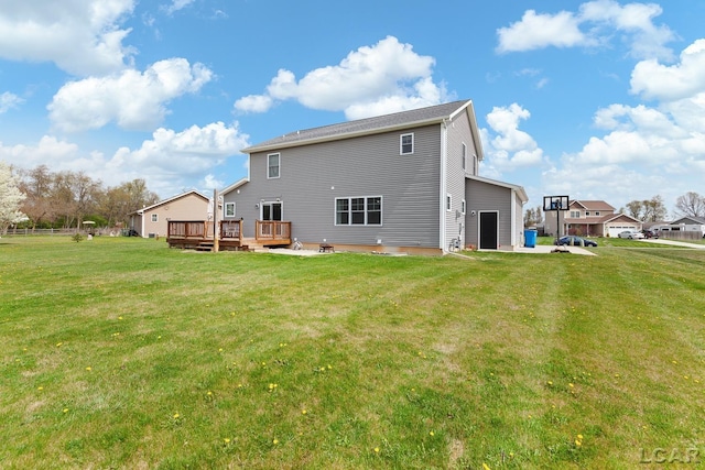 rear view of property with a lawn and a deck