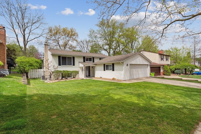 split level home featuring concrete driveway, a front yard, fence, and a garage