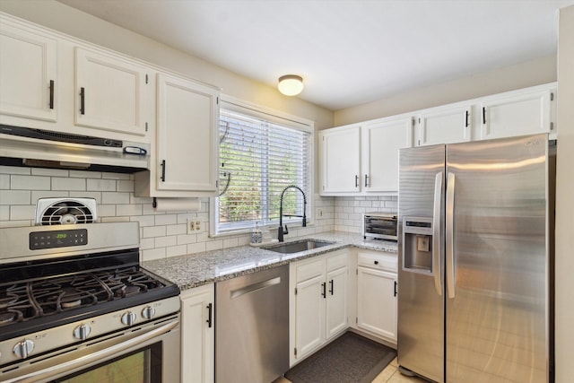 kitchen with under cabinet range hood, white cabinetry, stainless steel appliances, and a sink
