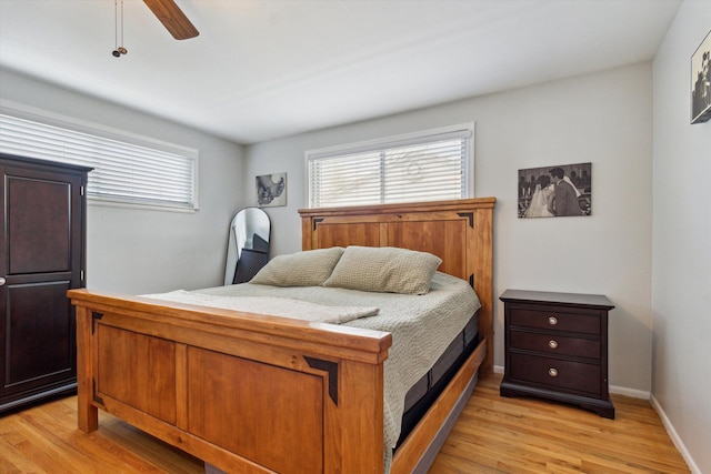 bedroom with baseboards, ceiling fan, and light wood-type flooring