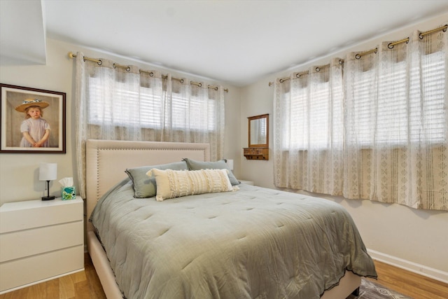 bedroom featuring baseboards and wood finished floors