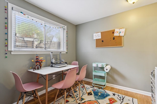 dining space with baseboards and wood finished floors
