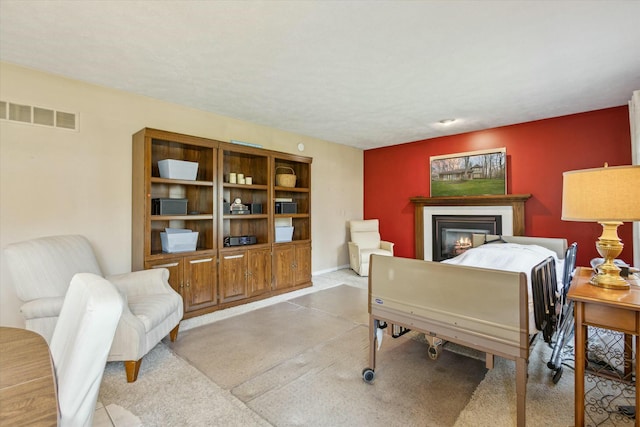 living area with a glass covered fireplace and visible vents