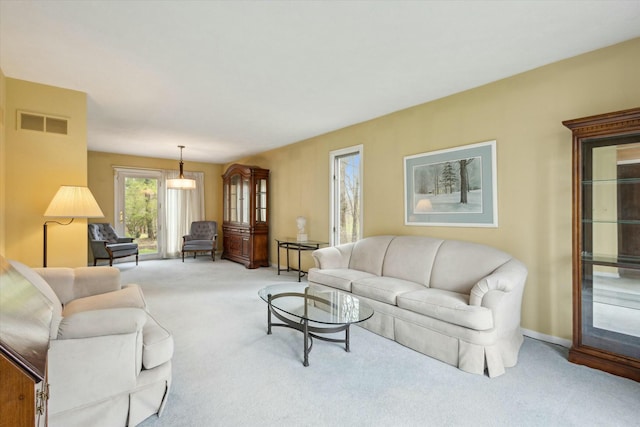 living room with baseboards, light colored carpet, and visible vents
