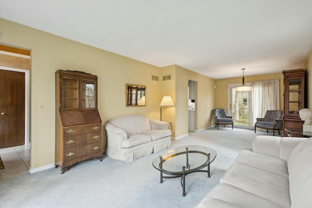 living room with baseboards, visible vents, and light colored carpet