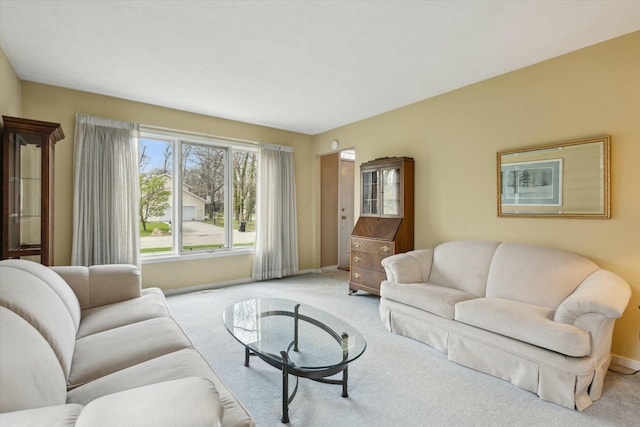 carpeted living area featuring baseboards