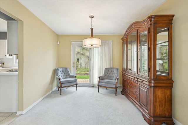 sitting room featuring baseboards and light colored carpet