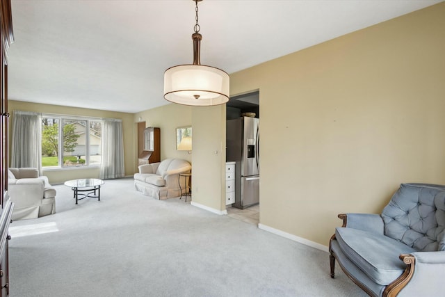 sitting room featuring baseboards and light carpet