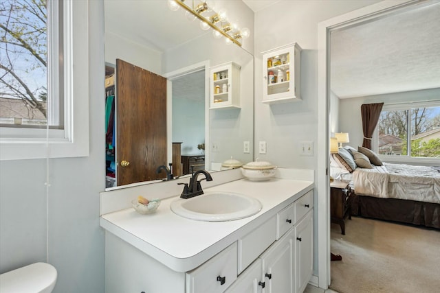 bathroom with toilet, ensuite bathroom, and vanity