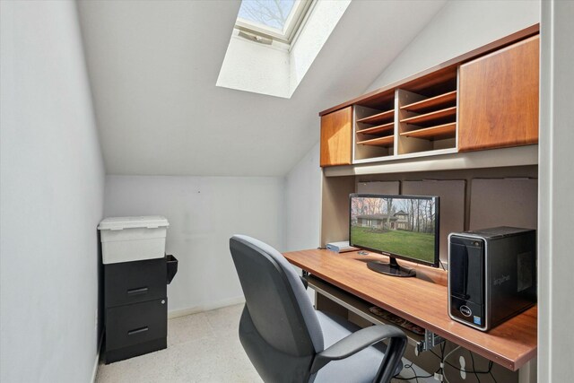 office space with baseboards and vaulted ceiling with skylight
