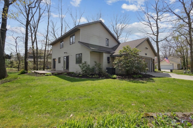 view of side of property featuring a yard, central AC, driveway, and a garage