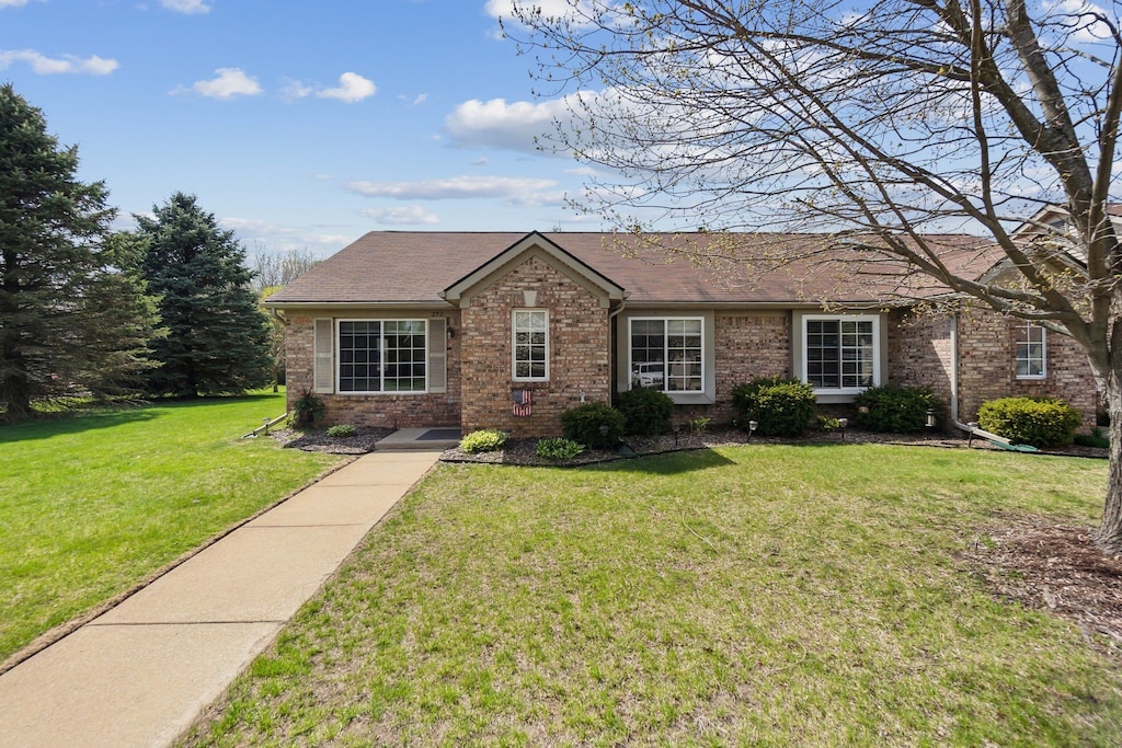 view of front of home featuring brick siding and a front lawn