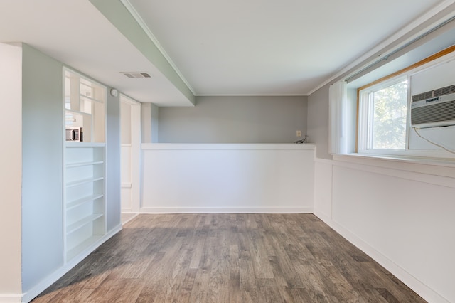 1298 E Highland Rd, Highland, MI 48356 - spare room featuring wood finished floors, built in shelves, and ornamental molding