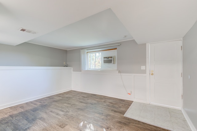 1298 E Highland Rd, Highland, MI 48356 - empty room featuring wood finished floors, wainscoting, and a wall mounted AC