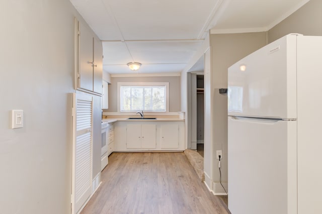1298 E Highland Rd, Highland, MI 48356 - kitchen with white appliances, a sink, light countertops, light wood-style flooring, and crown molding