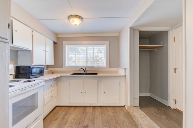 1298 E Highland Rd, Highland, MI 48356 - kitchen with a sink, white range with electric cooktop, black microwave, light countertops, and white cabinetry