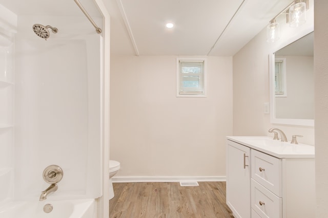 1298 E Highland Rd, Highland, MI 48356 - full bathroom with toilet, wood finished floors, vanity, washtub / shower combination, and baseboards