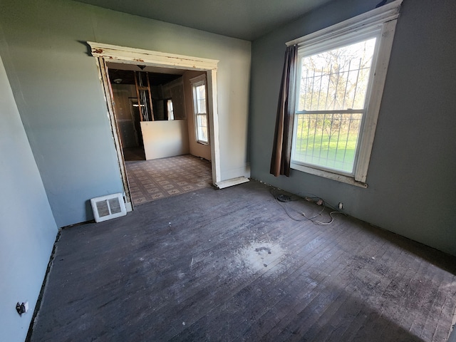 empty room featuring wood finished floors and visible vents
