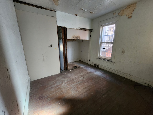 empty room with hardwood / wood-style floors and visible vents