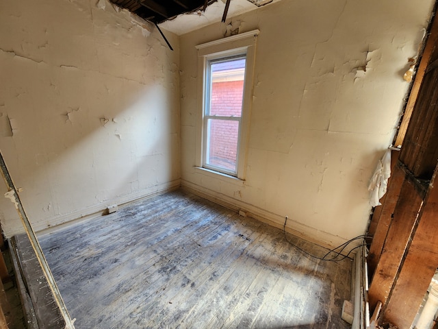 unfurnished room with baseboards and wood finished floors