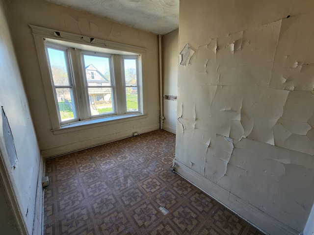 spare room with tile patterned floors and baseboards