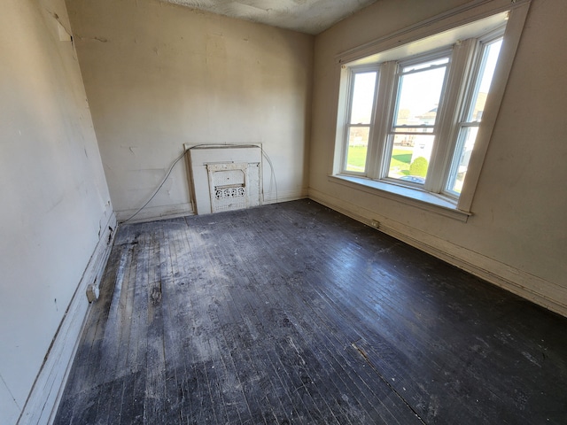 empty room with baseboards and wood-type flooring