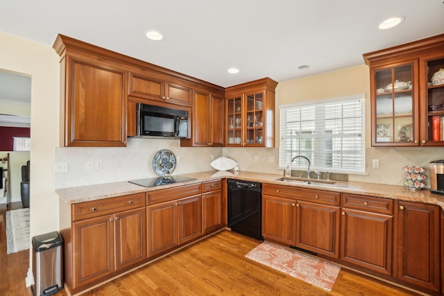 29044 Thistle Ln, Harrison Township, MI 48045 - kitchen with light wood-style floors, a sink, black appliances, and tasteful backsplash