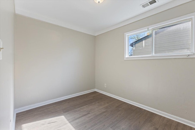 unfurnished room with visible vents, baseboards, and wood finished floors