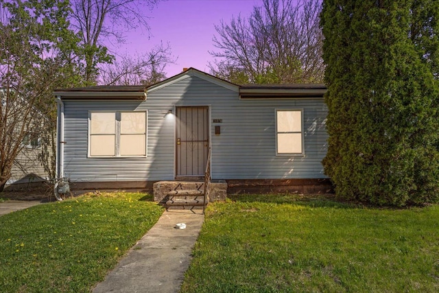 view of front facade featuring a lawn and entry steps