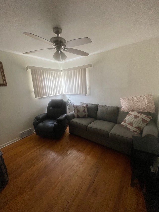 living room featuring ceiling fan, wood finished floors, and visible vents