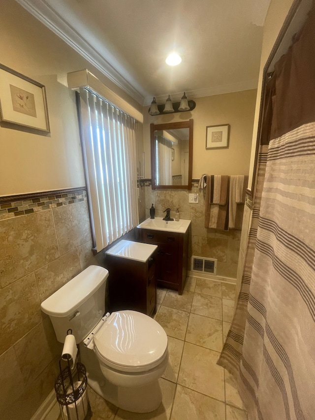 bathroom featuring tile walls, a wainscoted wall, toilet, and visible vents
