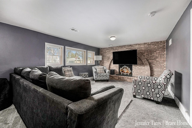 living room featuring visible vents, carpet, and a fireplace