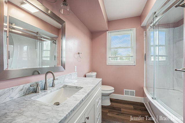 full bathroom featuring vanity, toilet, baseboards, wood finished floors, and visible vents