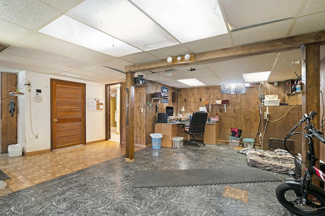 office with baseboards, tile patterned floors, a drop ceiling, and wooden walls