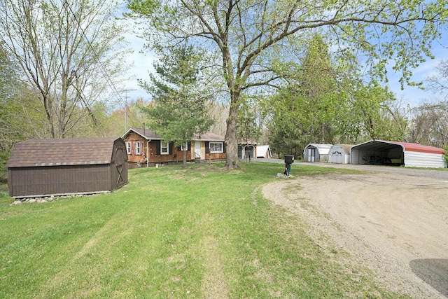 view of yard featuring an outdoor structure, driveway, a shed, and a carport