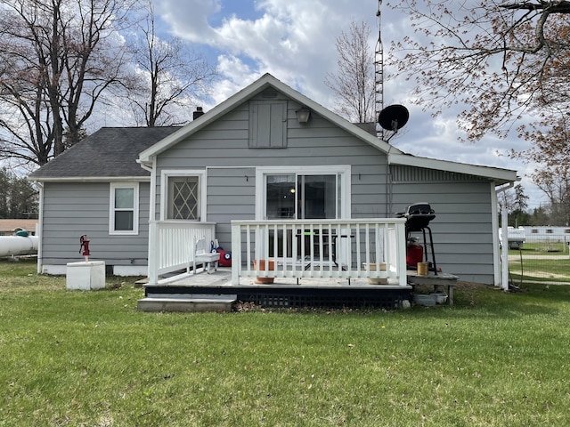 rear view of property featuring a lawn, a wooden deck, and a chimney