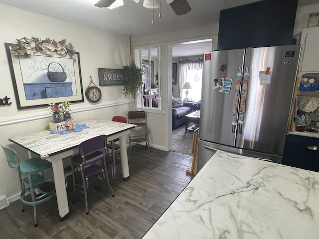 dining room with visible vents, a ceiling fan, dark wood finished floors, and a wainscoted wall