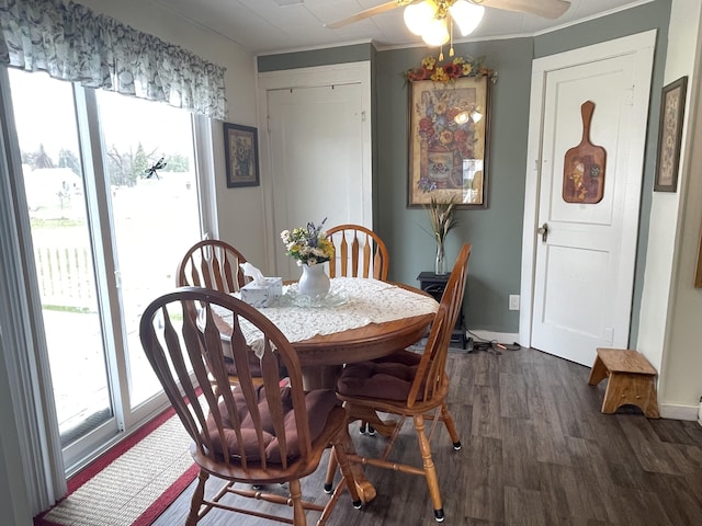 dining space featuring baseboards, dark wood-style flooring, ceiling fan, and a wealth of natural light