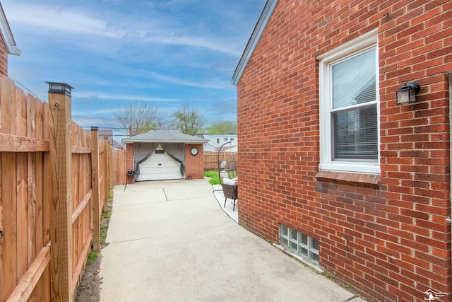 view of property exterior with brick siding, fence, and an outbuilding