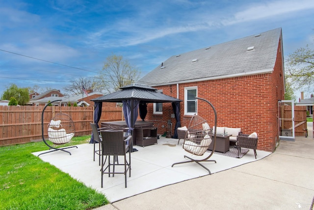 back of property featuring fence, a patio, roof with shingles, brick siding, and a gazebo