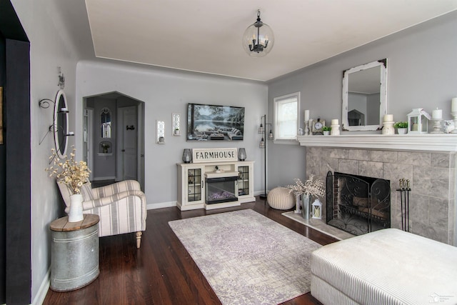 living area with baseboards, wood finished floors, and a fireplace