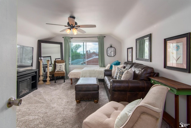 living room with carpet flooring, a ceiling fan, and vaulted ceiling