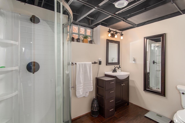 bathroom with vanity, a stall shower, and wood finished floors