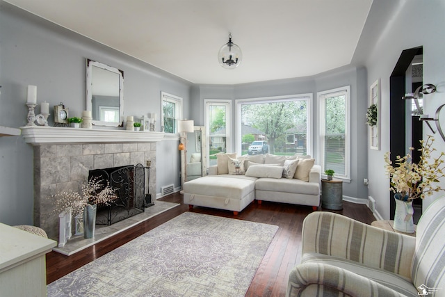 living area featuring visible vents, wood-type flooring, baseboards, and a fireplace
