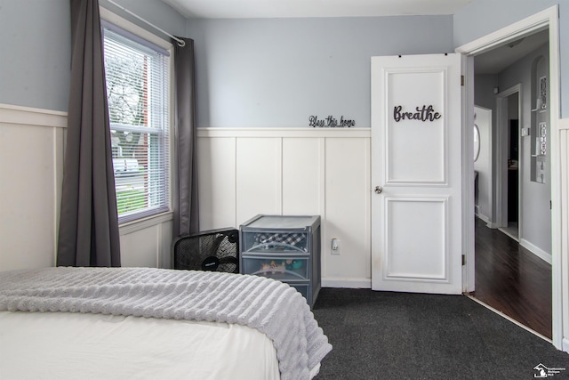 bedroom with carpet and a wainscoted wall