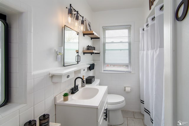 bathroom with vanity, a shower with shower curtain, toilet, and tile walls