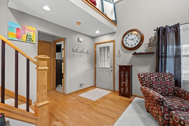 entrance foyer with visible vents, baseboards, stairs, and wood finished floors