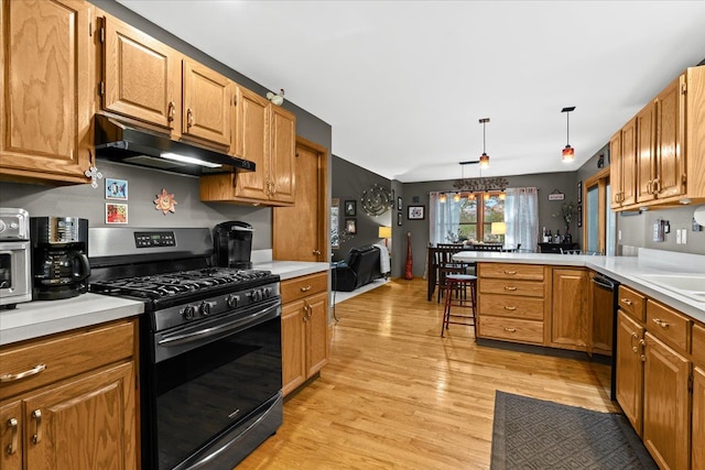 kitchen featuring a peninsula, light wood-style floors, stainless steel gas range oven, light countertops, and under cabinet range hood