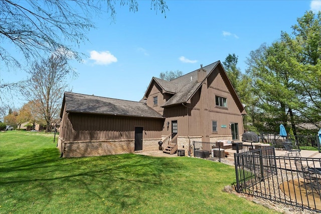 rear view of property featuring fence, a patio, board and batten siding, entry steps, and a yard